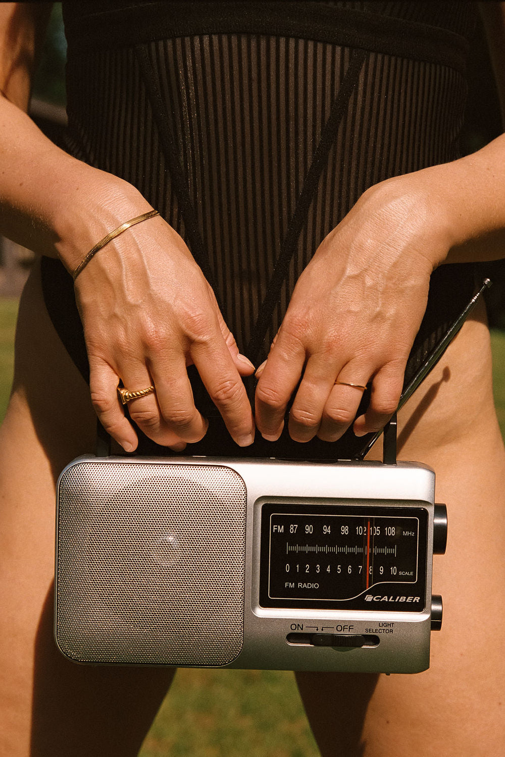 radio voor lichaam met gouden sieraden en in zwart gestreept lingerie bodysuit