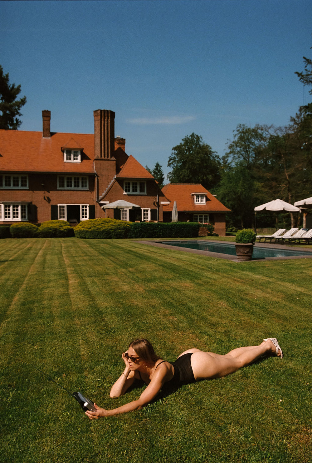 geraldine kemper liggend met radio in zwarte lingerie body in het gras