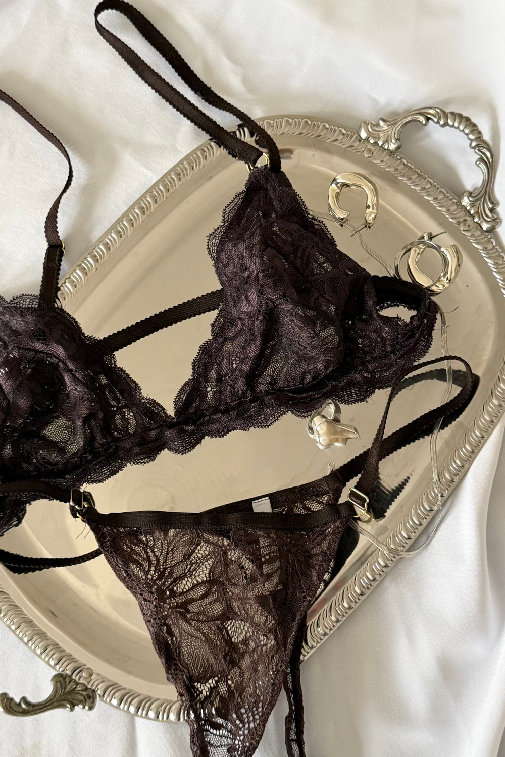 bruin kanten lingerie setje op zilveren schaal met zilveren sieraden
