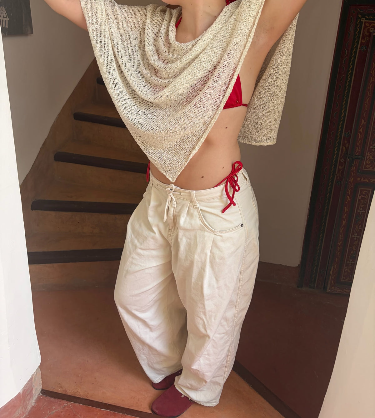 meisje in witte broek en wit cape top met rode bikini 