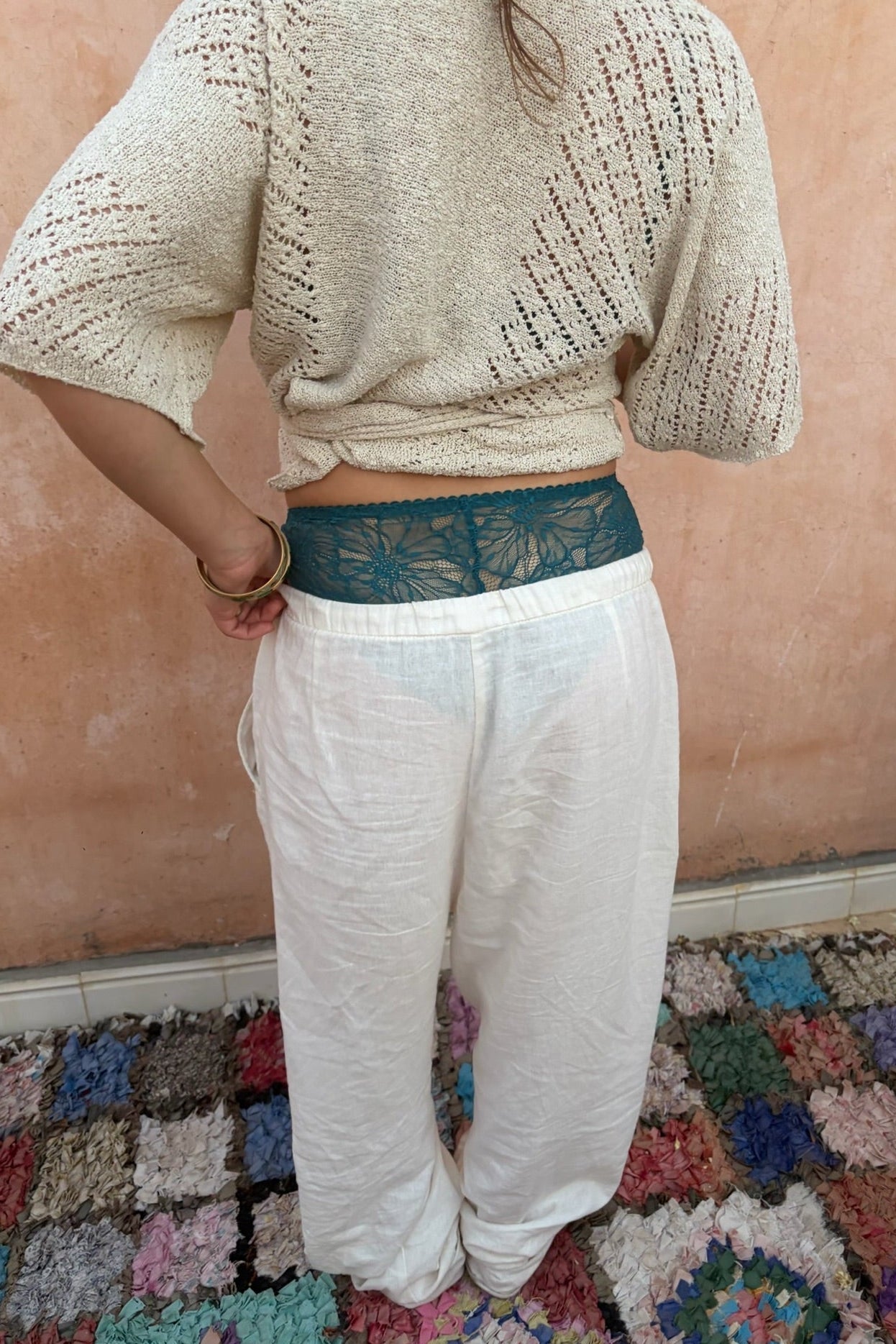 foto achterkant witte linnen broek en gehaakte top met blauw lingerie broekje die uitsteekt