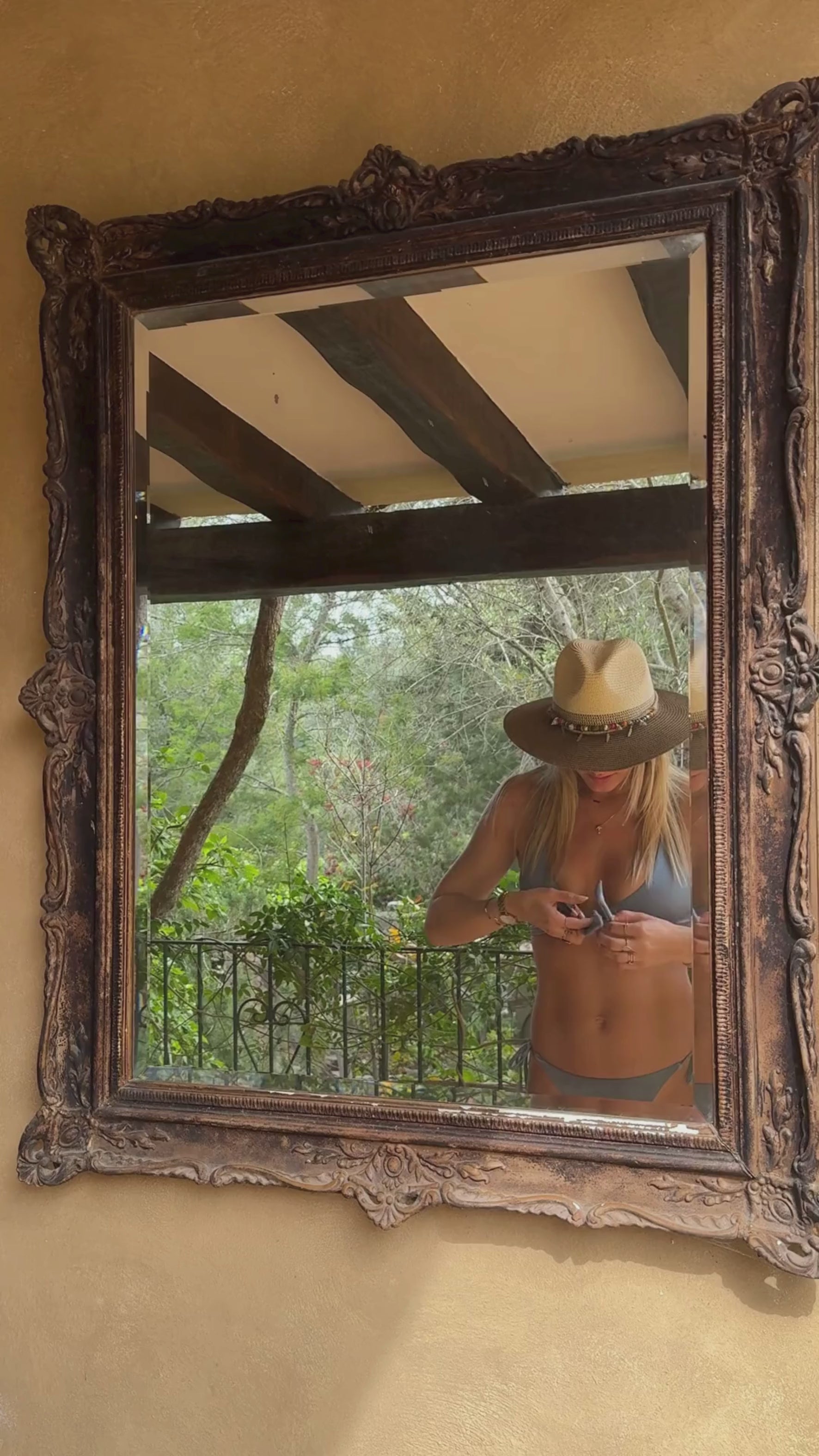 model in lichtblauwe strik bikini die ze strikt in de spiegel
